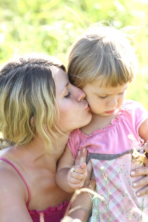 Beautiful little girl with her mother on the natureの写真素材