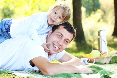 father with child playing on the grassの写真素材