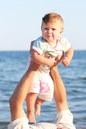 father with a small daughter at the sea shoreの写真素材