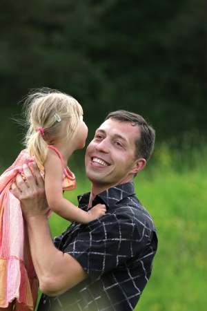 beautiful little girl play with dad in natureの写真素材