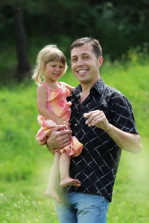 beautiful little girl play with dad in natureの写真素材
