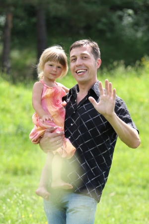 beautiful little girl play with dad in natureの写真素材