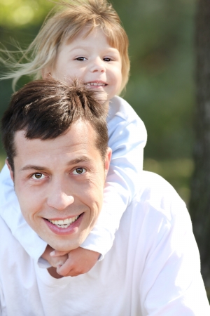 beautiful little girl play with dad in natureの写真素材