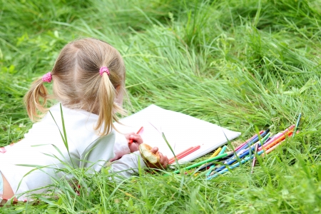 beautiful little girl paint pencil on nature,の写真素材