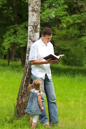 young father with baby daughter reading the Bibleの写真素材