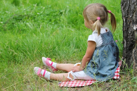 beautiful little girl on nature near treeの写真素材