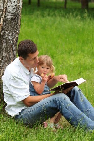 young father with baby daughter reading the Bibleの写真素材