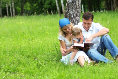 young family with a young daughter reads the Bibleの写真素材