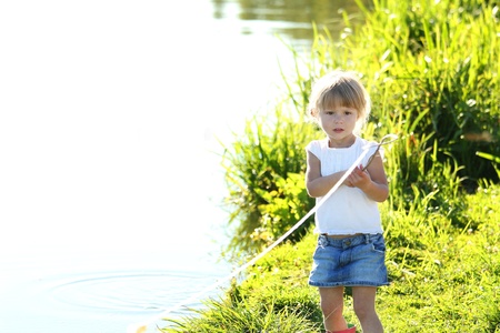 beautiful little girl on nature near lakeの写真素材
