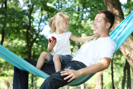 young father with his small daughter in a hammockの写真素材