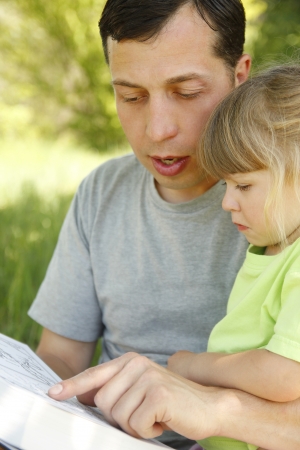father with his little daughter reads the Bibleの写真素材
