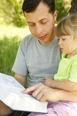 young father with his little daughter reads the Bibleの写真素材