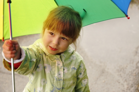 little girl with an umbrella in the rainの写真素材