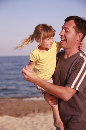 a father and daughter on the sea shoreの写真素材