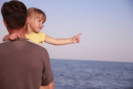 a father and daughter on the sea shoreの写真素材