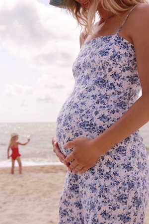 pregnant woman on the beach with little childの写真素材