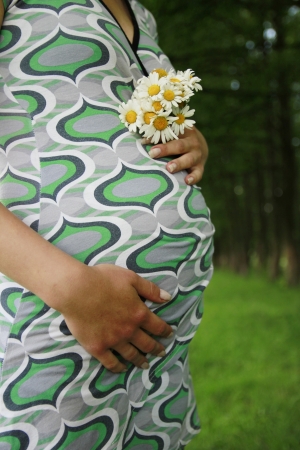 a belly of a pregnant woman on the natureの写真素材