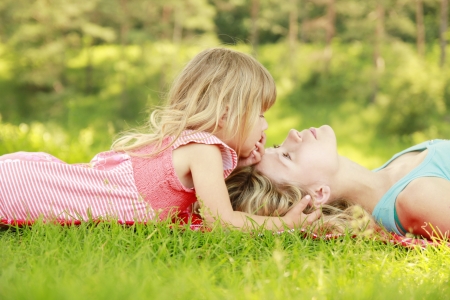 a Mama and her little daughter playing on grassの写真素材