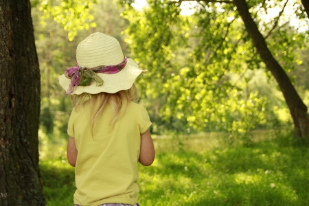 a beautiful little girl in a hat on the natureの写真素材