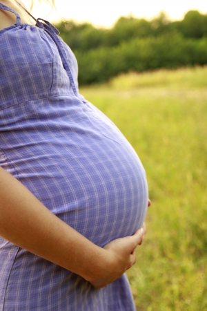 a belly beautiful young pregnant girl in natureの写真素材