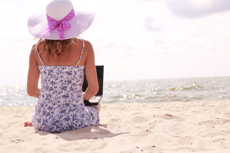 a girl with laptop on the beachの写真素材