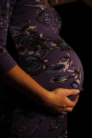 a pregnant woman on a black  background の写真素材