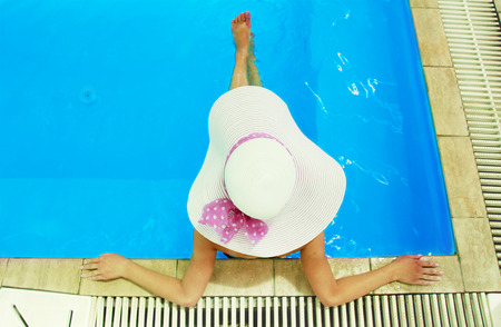 a girl with a hat in the water poolの写真素材