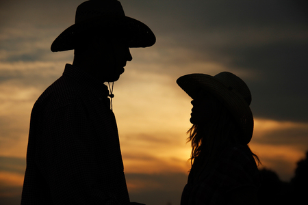 a young couple in love on haystacks in cowboy hatsの写真素材