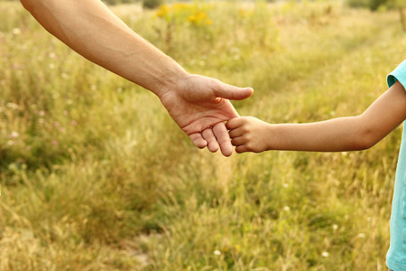 the parent holds the hand of a small childの写真素材