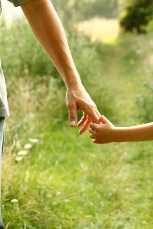 the parent holds the hand of a small childの写真素材