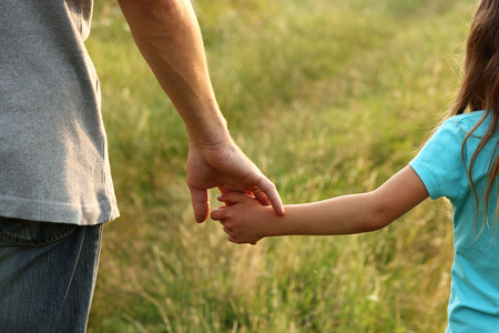the parent holds the hand of a small childの写真素材