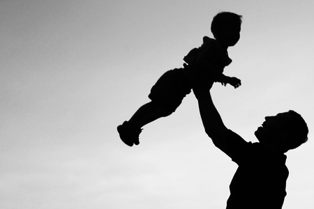 silhouette of father and son play on sunsetの写真素材