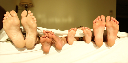 a Feet of the family on the bed
