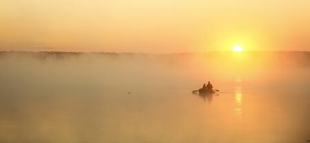 a father and son silhouette on a boatの写真素材