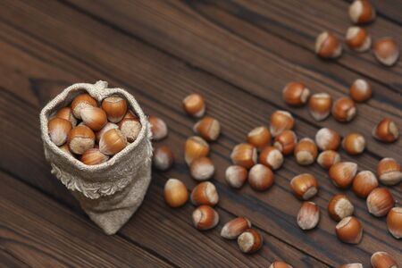 hazelnut in a bag on a wooden backgroundの写真素材