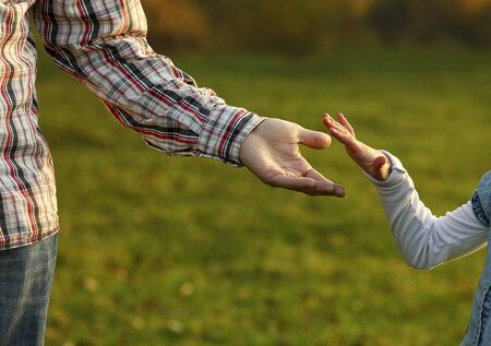the parent holds the hand of a small child