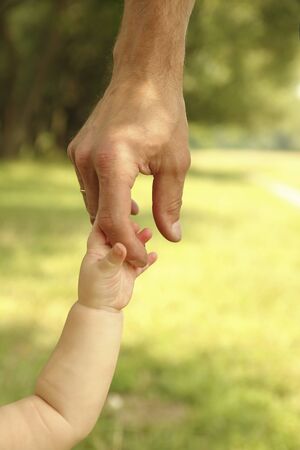 the parent holds the hand of a small childの写真素材