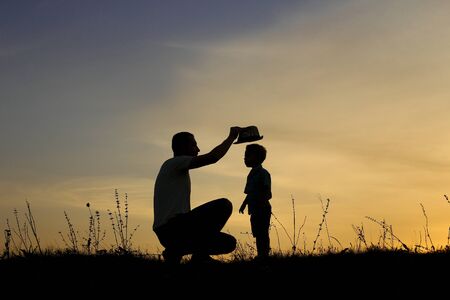 silhouette of happy father and son play on sunsetの写真素材