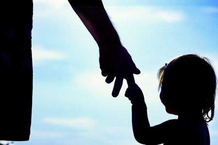 happy parent with child in nature by the sea silhouetteの写真素材