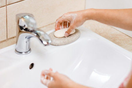 Washing hands with soap under the faucet with water