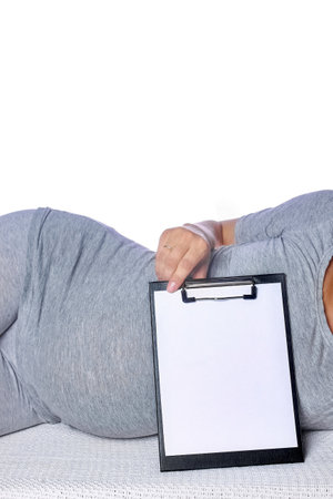 Happy pregnant girl lies on white backgroundの写真素材