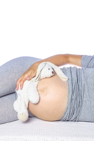 Happy pregnant girl lies on white backgroundの写真素材