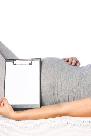 Happy pregnant girl lies on white backgroundの写真素材