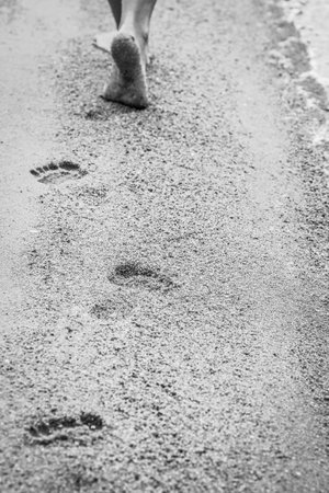 beautiful footprints in the sand by the sea backgroundの写真素材