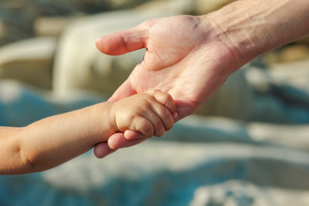 beautiful hands of parent and child by the seaの写真素材