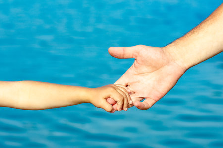 beautiful hands of parent and child by the seaの写真素材