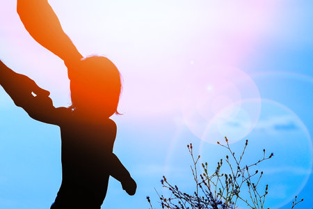 happy parent with child in nature by the sea silhouetteの写真素材