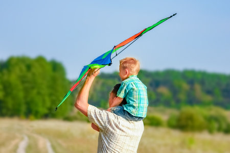 Happy father and child playing in nature in summerの写真素材