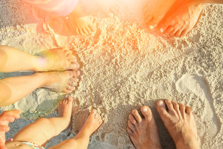 beautiful family legs on the sand by the seaの写真素材