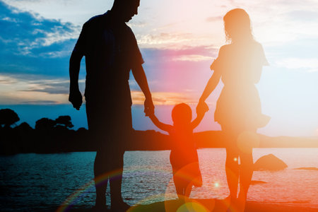 happy family by the sea on nature silhouette backgroundの写真素材